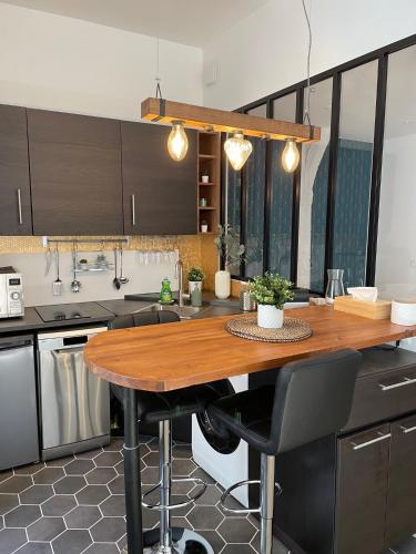 une cuisine avec une table en bois au milieu dans l'établissement Le Studio Cosy, à Orléans