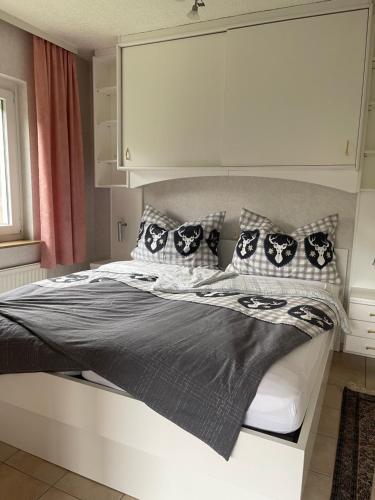 a bedroom with a bed with black and white pillows at Seeappartement LUNA am Ossiachersee in Bodensdorf