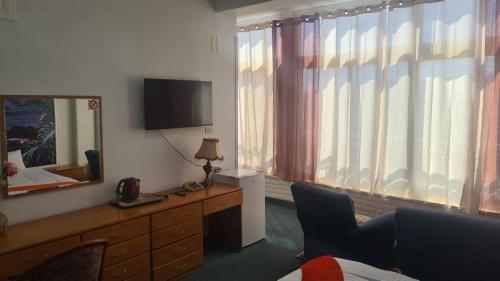 a room with a mirror and a dresser with a television at Jerusalem Panorama Hotel in Jerusalem