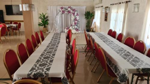 - une longue table dans une pièce avec des chaises rouges dans l'établissement Jerusalem Panorama Hotel, à Jérusalem