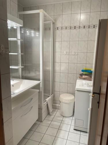 baño blanco con ducha y lavamanos en Seeappartement LUNA am Ossiachersee, en Bodensdorf