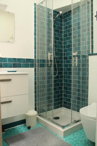 La salle de bains est pourvue d'une douche en verre et de toilettes. dans l'établissement La Goélette Beau duplex A 150 m du centre ville et 400m de la plage de l'écluse, à Dinard