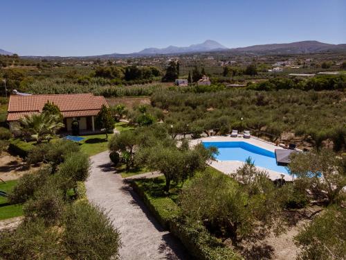 an aerial view of a villa with a swimming pool and trees at Villas Lefkothea with Large Pool, Playground Area, & Magnificent Views! in Adelianos Kampos