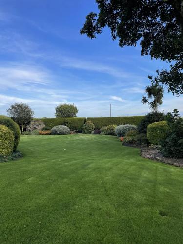 a large yard with green grass and bushes at Galloway Farmstay Claunch in Newton Stewart