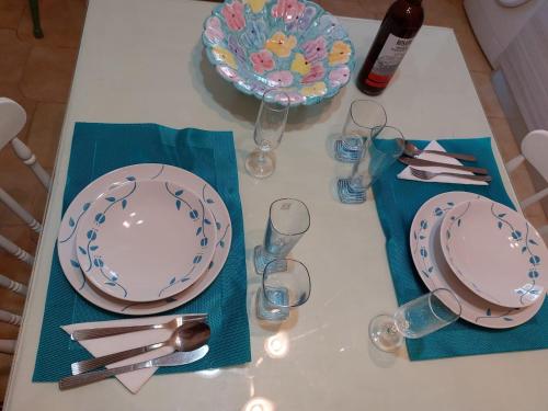 a table with plates and glasses on a table at Casa Mami' in Marigliano
