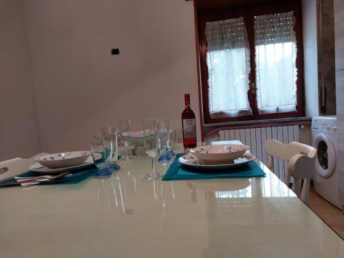 a dining room table with glasses and a bottle of wine at Casa Mami' in Marigliano