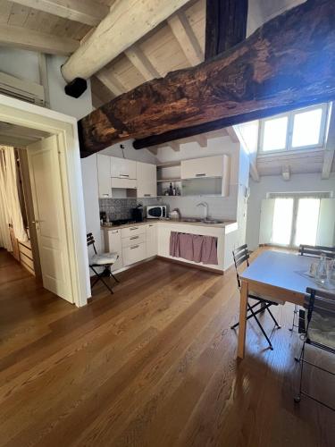 a kitchen with white cabinets and a wooden floor at Locanda Mimmo in Bergamo