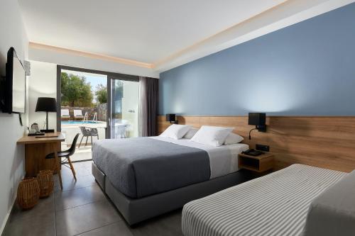 a hotel room with two beds and a balcony at Sentido Amounda Bay in Amoudara Herakliou