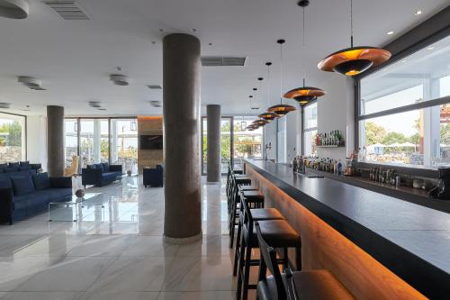 a lobby with a bar with chairs and tables at Sentido Amounda Bay in Amoudara Herakliou