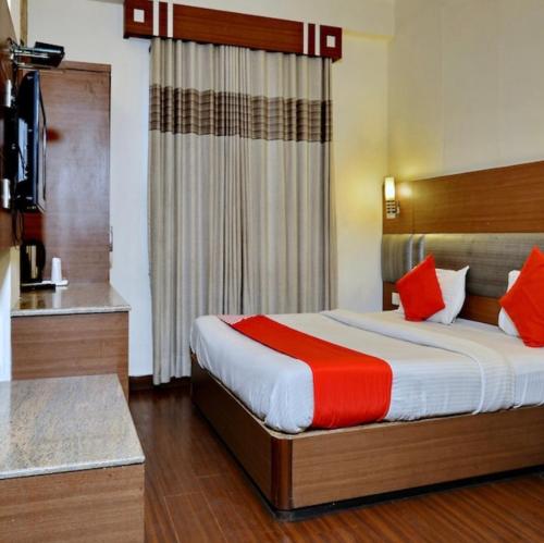 a bedroom with a large bed with red pillows at Hotel aroma classic in Jaipur