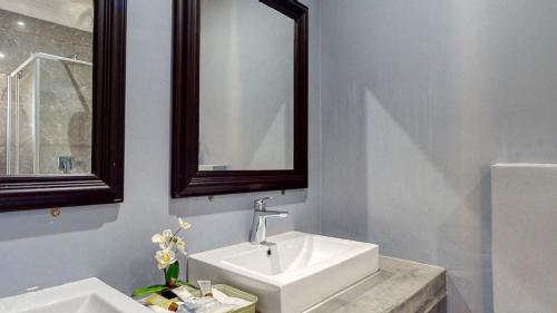a white bathroom with a sink and a mirror at Caribbean Estates Lakeview Villa in Port Edward