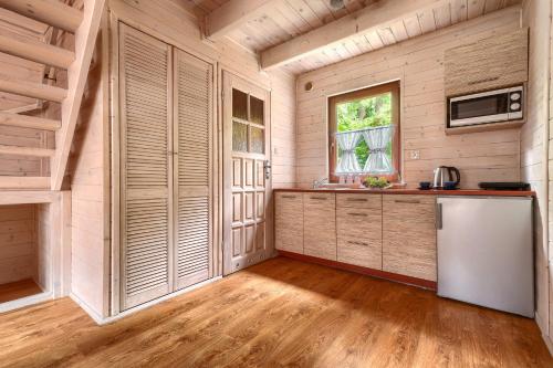 a kitchen in a log cabin with a refrigerator at Zacisze Morskie in Sarbinowo
