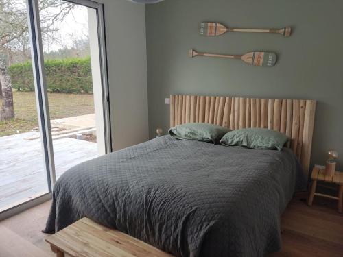 ein Schlafzimmer mit einem Bett und einem großen Fenster in der Unterkunft cottage chaleureux proche de l'océan in Grayan-et-lʼHôpital