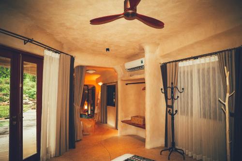 a ceiling fan in a living room with a window at Amaya Retreat in Sóc Sơn