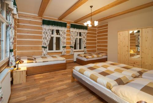 スピンドレルフ・ムリンにあるApartmán 3 Špindlerův Mlýnの木製の壁のベッドルーム1室(ベッド2台付)