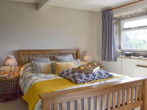 a bedroom with a wooden bed with a yellow blanket at Club House in Hebden Bridge