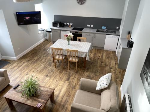 uma sala de estar com uma mesa e uma cozinha em Galloway Farmstay Claunch em Newton Stewart