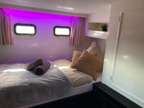 a bedroom with a bed with purple lights on it at Fantasie Boot EINHORN in Cologne