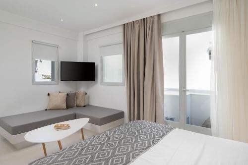 a hotel room with a bed and a table in it at Cycladic Suites & Spa in Fira
