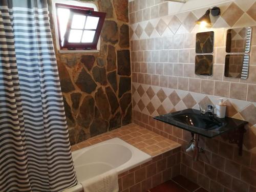 een badkamer met een wastafel, een bad en een wastafel bij Casa Monreal in Reguengos de Monsaraz