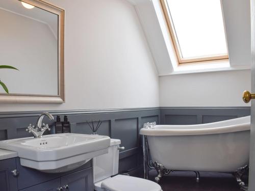 a bathroom with a sink and a tub and a toilet at Smiddy Cottage in Aberfeldy