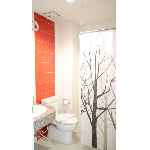a bathroom with a toilet and a shower curtain with trees at Chiangmai residence in Chiang Mai