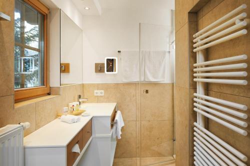 W łazience znajduje się umywalka i lustro. w obiekcie Habachklause Familien Bauernhof Resort w mieście Bramberg am Wildkogel