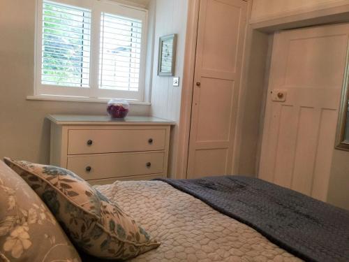 a bedroom with a bed and a window and a dresser at Sunrise Cottage in Linton
