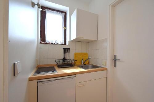 a small kitchen with a sink and a window at Apartments Cordasev in Vantačići