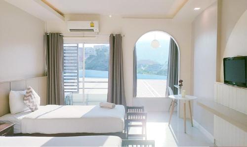 a hotel room with two beds and a window at Chiangmai residence in Chiang Mai
