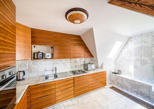 eine Küche mit Holzschränken und einem Waschbecken in der Unterkunft Triplex Kings Apartment in Old Town in Prag