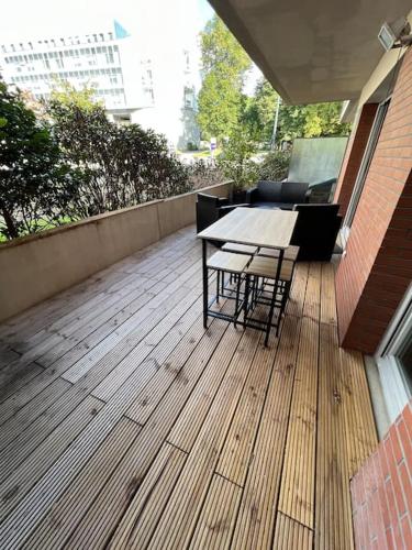 a wooden deck with a table and chairs on a building at Le Roazhon, Rennes métropole in Rennes