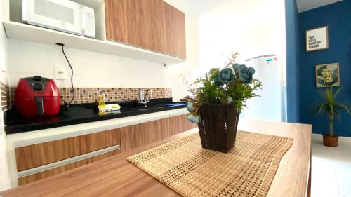 a kitchen with a vase with a plant on a table at Hotel APART Zuccolotto 202 in Aracruz