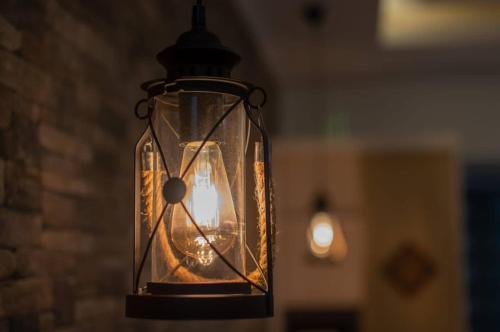 a glass lantern hanging on a brick wall at Treasure Villa in Anse Possession