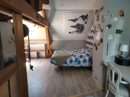 a small bedroom with a bed and a desk at Chez Laetitia in Gérardmer