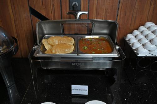 a plate of food on top of a toaster at Hotel Tip Top International Pune in Pune