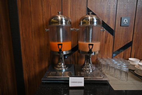 a couple of glasses of orange juice and a blender at Hotel Tip Top International Pune in Pune