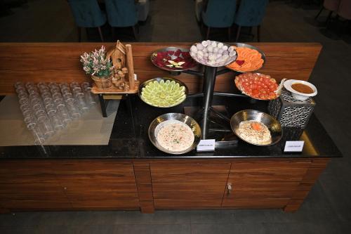 a table with many bowls of food on it at Hotel Tip Top International Pune in Pune