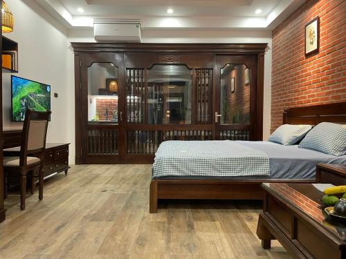 a bedroom with a bed and a desk and a television at Eco nest in Hanoi