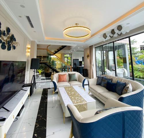 ein Wohnzimmer mit Sofas und einem großen Fernseher in der Unterkunft Amun Villa - Venuestay in Vĩnh Phúc