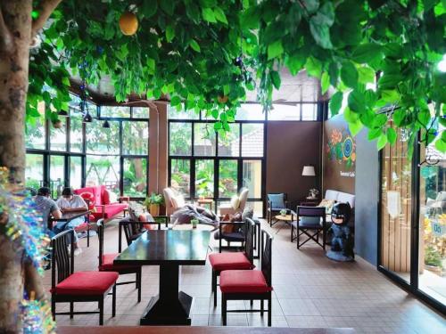 - un restaurant avec des tables et des chaises dans l'établissement Tamarind ณ บางคล้า ที่พักริมแม่น้ำ, à Ban Khlong Tha Thong Lang