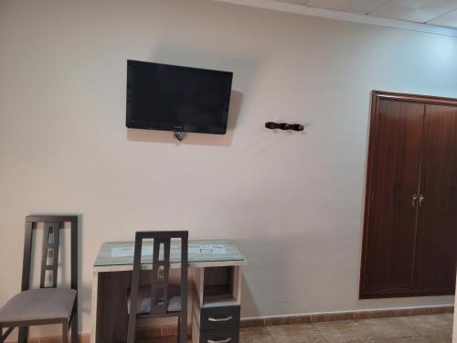 TV de pantalla plana colgada en la pared en Hostal Restaurante el Paraíso, en Don Benito