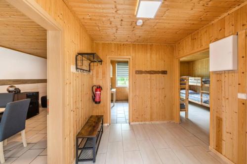 a room with wooden walls and a hallway with bunk beds at Bungalow 02 in Sondershausen