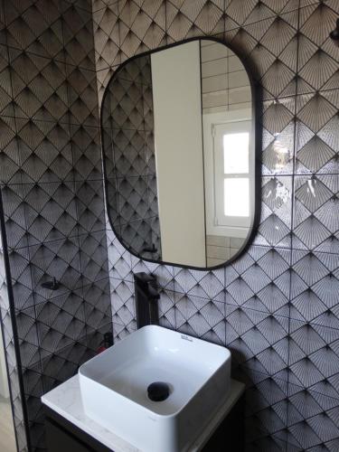 y baño con lavabo blanco y espejo. en 60 Indri Borg Townhouse, en Rabat