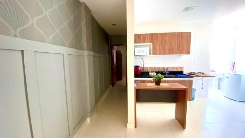 a kitchen with a table in the middle of a room at Hotel APART Zuccolotto 202 in Aracruz