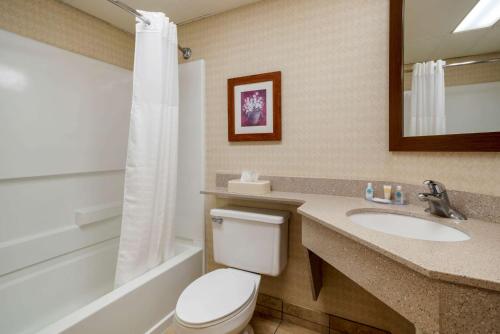 a bathroom with a toilet, sink, and bathtub at Comfort Inn Boardwalk in Ocean City