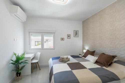 ein Schlafzimmer mit einem Bett und einem Schreibtisch darin in der Unterkunft Fantástica Villa Cusmano con piscina privada in Adeje