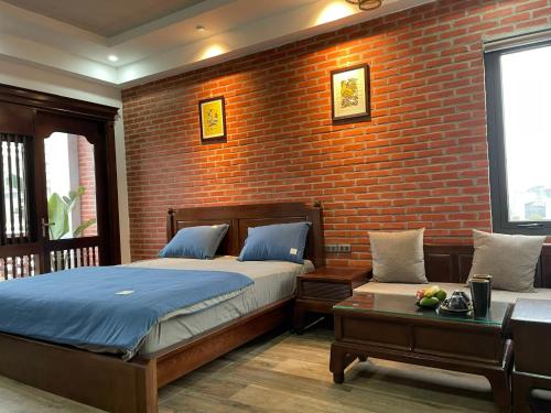 um quarto com uma cama e uma parede de tijolos em Eco nest em Hanói