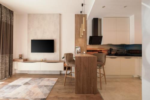 een woonkamer met een keuken met een bar en een televisie bij Great Time Apartman in Hévíz