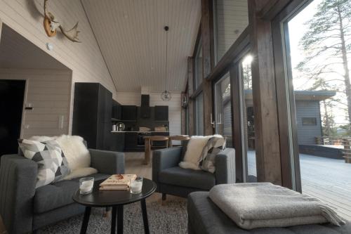uma sala de estar com duas cadeiras e uma mesa em Norlight Cottages Ivalo - Tuli em Ivalo